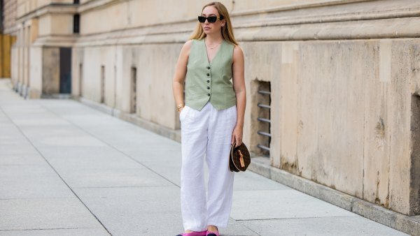 BERLIN, GERMANY - JULY 01: Sonia Lyson wears pink black Chanel ballerinas, white linen pants & green vest Zara, Louis Vuitton bag, sunglasses Miu Miu during the Berlin Fashion Week Spring/Summer 2025 on July 01, 2024 in Berlin, Germany. (Photo by Christian Vierig/Getty Images)