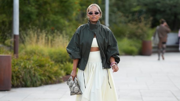 COPENHAGEN, DENMARK - AUGUST 6: Nicole Reed wears pink rectangular sunglasses, gold statement earrings, a dark green oversized leather jacket over a cream crop top and matching high waisted full midi skirt, carries a snakeskin print clutch and wears cream pointed shoes outside the Collina Strada show during day 4 of Copenhagen Fashion Week Spring Summer 2027 on August 6, 2026 in Copenhagen, Denmark. (Photo by Moritz Scholz/Getty Images)