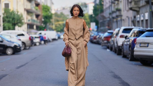 MILAN, ITALY - SEPTEMBER 25: Chen Yinxin wears a short chin-length bob haircut, dark brown with lighter brown highlights, side-parted, a burgundy leather top-handle bag, a chunky camel cable-knit wool cardigan draped off the shoulders, a sleeveless camel wool button-front vest with a high round neckline and tan buttons, matching camel wool wide-leg trousers, burgundy leather low-heel round-toe shoes, outside Max Mara, during Milan Fashion Week - Womenswear Spring/Summer 2026, on September 25, 2025 in Milan, Italy (Photo by Edward Berthelot/Getty Images)