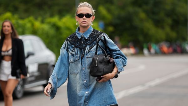 COPENHAGEN, DENMARK – AUGUST 4: A guest is seen wearing an oversized denim shirt dress with a black lace bib collar, white socks, black ballet flats and carrying a black leather handbag outside the Skall Studio show during Day Two of Copenhagen Fashion Week Spring Summer 2027 on August 4, 2026 in Copenhagen, Denmark. (Photo by Moritz Scholz/Getty Images)