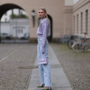 BERLIN, GERMANY - OCTOBER 15: Carolin Niemczyk wearing Rotate lilac knit logo sweater, Jacquemus lilac bag, Gina Tricot wide leg baby blue denim jeans and Amina Muaddi green sparkling slingback pumps on October 15, 2022 in Berlin, Germany. (Photo by Jeremy Moeller/Getty Images)