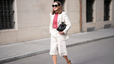 MUNICH, GERMANY - MARCH 27: Annette Weber is seen wearing a light beige tailored suit with a relaxed fit, consisting of a single breasted blazer and knee length tailored shorts from Max Mara; a red blouse with white polka dots and a soft high neckline from Glamometer and Seidensticker; black leather heeled sandals with a delicate ankle strap and bow detail from Ferragamo; a small black clutch bag with a textured leather finish from Max Mara; oversized black sunglasses with a bold frame from Gucci; her brown hair is worn loose with a natural finish and a center part on March 27, 2026 in Munich, Germany. (Photo by Moritz Scholz/Getty Images)