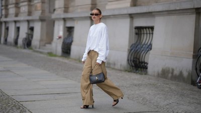 BERLIN, GERMANY - JULY 23: Sophia Geiss is seen wearing an oversized white crew neck sweatshirt from Black Palms; beige oversized wide leg cargo trousers with utility patch pockets from The Frankie Shop; black leather thong sandals from Mango; a black smooth leather Saint Laurent Le 5 à 7 Hobo shoulder bag with the signature gold tone YSL hook closure; black narrow oval frame sunglasses from Saint Laurent; silver hoop earrings on July 23, 2026 in Berlin, Germany. (Photo by Moritz Scholz/Getty Images)
