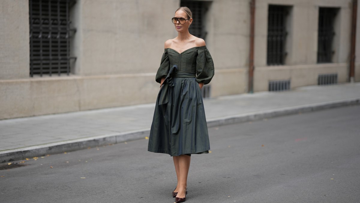 MUNICH, GERMANY - SEPTEMBER 1: Mirja Klein is seen wearing a off-the-shoulder dark green midi dress with voluminous, puffed sleeves and subtle floral texture throughout the bodice, the skirt is full and structured, cinched at the waist with a wide, matching sash tied in a bow from Cocovero; pointed-toe heels in a burgundy patent leather from Mango; oversized brown-tinted aviator sunglasses with a thin frame from Tom Ford; her blonde hair is pulled back in a sleek low bun on September 1, 2025 in Munich, Germany. (Photo by Moritz Scholz/Getty Images)