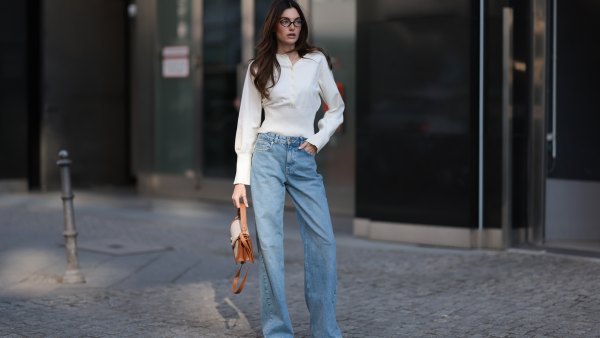 BERLIN, GERMANY - MARCH 21: Celine Bethmann seen wearing Miu Miu brown oval framed statement glasses, Cie Cie fitted ivory long-sleeve cotton henley top with a structured waist detail, Cie Cie high-waisted, light-wash wide-leg jeans that add a relaxed yet sophisticated touch, Cochinelle two-tone leather handbag in beige and brown, adding an elegant contrast and Alohas classic soft cream suede and light brown leather sneakers with a vintage-inspired silhouette, on March 21, 2025 in Berlin, Germany. (Photo by Jeremy Moeller/Getty Images)