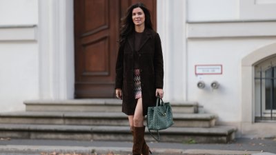 BERLIN, GERMANY - AUGUST 24: Leo Eberlin seen wearing Leo Mathild diamond jewelry / white gold diamond rings, Zara chocolate brown suede leather long coat with a straight silhouette, Zara brown crewneck cashmere knit sweater, Missoni multicolored mini skirt in a zigzag chevron pattern, featuring tones of pink, cream, black, and green, adding a playful retro-inspired touch, Bottega Veneta Andiamo woven sage green leather bag and Saint Laurent brown suede leather knee-high heeled boots, on August 24, 2025 in Berlin, Germany. (Photo by Jeremy Moeller/Getty Images)