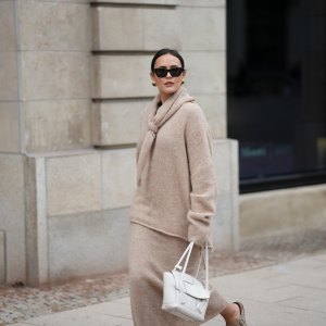 Laura Noltemeyer is seen wearing an oversized beige alpaca wool sweater with tie-back detailing by Aylin König; a long alpaca wool knit skirt in a straight cut by Aylin König; an alpaca knit scarf draped and knotted around the neck by Aylin König; a white intrecciato leather handbag called „Arco Bag“ by Bottega Veneta; slim black cat-eye sunglasses by Yves Saint Laurent; gold statement earrings with a green stone detail by Mango; her brown and straight hair is tied in a low ponytail on October 16, 2025 in Hamburg, Germany.