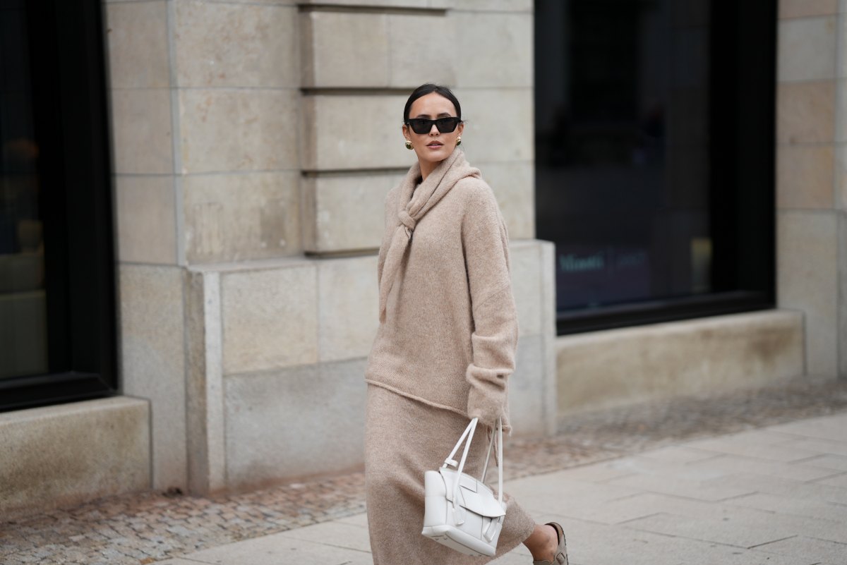 Laura Noltemeyer is seen wearing an oversized beige alpaca wool sweater with tie-back detailing by Aylin König; a long alpaca wool knit skirt in a straight cut by Aylin König; an alpaca knit scarf draped and knotted around the neck by Aylin König; a white intrecciato leather handbag called „Arco Bag“ by Bottega Veneta; slim black cat-eye sunglasses by Yves Saint Laurent; gold statement earrings with a green stone detail by Mango; her brown and straight hair is tied in a low ponytail on October 16, 2025 in Hamburg, Germany.