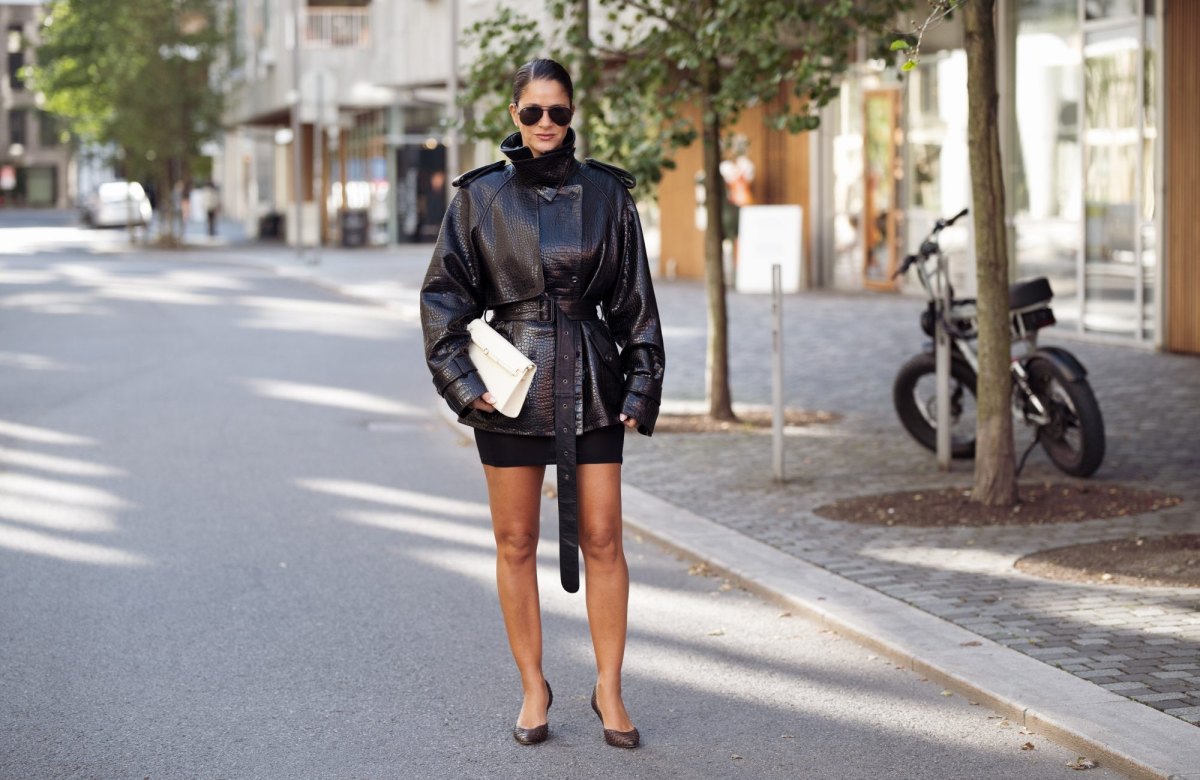 OSLO, NORWAY - SEPTEMBER 03: Gili Biegun wears a black croc-effect leather belted jacket with a high collar and oversized shoulders over a black fitted mini skirt, black Ray-Ban aviator sunglasses, a cream structured clutch and dark brown pointed heels in python leather during Oslo Runway Fashion Week on September 03, 2026 in Oslo, Norway. (Photo by Raimonda Kulikauskiene/Getty Images)