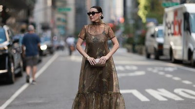 NEW YORK, NEW YORK - SEPTEMBER 12: Yana Echko seen wearing YSL oversized brown cat-eye sunglasses, Jennifer Fisher gold statement hoop earrings, Staud sheer green / brown floor-length dress with short sleeves and an all-over green floral design, Cult Gaia champagne-gold small clutch with clasp closure and strappy gold metallic heels, outside the Christian Siriano show, during New York Fashion Week, on September 12, 2025 in New York City. (Photo by Jeremy Moeller/Getty Images)