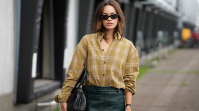 AMSTERDAM, NETHERLANDS - SEPTEMBER 2: Sarah Wattimena wears a mustard and beige plaid button down shirt with rolled sleeves, a dark green crocodile effect midi pencil skirt, black oval sunglasses, a black leather handbag and a black wristwatch, with shoulder length brunette hair styled in soft layers outside the Tess van Zalinge show during day 2 of Amsterdam Fashion Week on September 2, 2026 in Amsterdam, Netherlands. (Photo by Moritz Scholz/Getty Images)