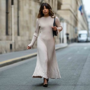 PARIS, FRANCE - NOVEMBER 07: Ellie Delphine wears a beige stripped long dress, a black leather bag, black leather ballerinas shoes, during a street style fashion photo session, on November 07, 2024 in Paris, France. (Photo by Edward Berthelot/Getty Images)