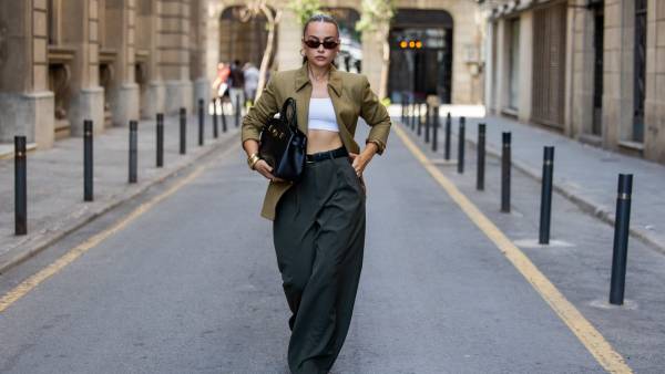 BARCELONA, SPAIN - AUGUST 11: Anna Wein wears green blazer Hermes, grey wide leg pants Rossi Pants, heels YSL, black bag Demellier London, sunglasses Corlin Eyewear on August 11, 2025 in Barcelona, Spain. (Photo by Christian Vierig/Getty Images)