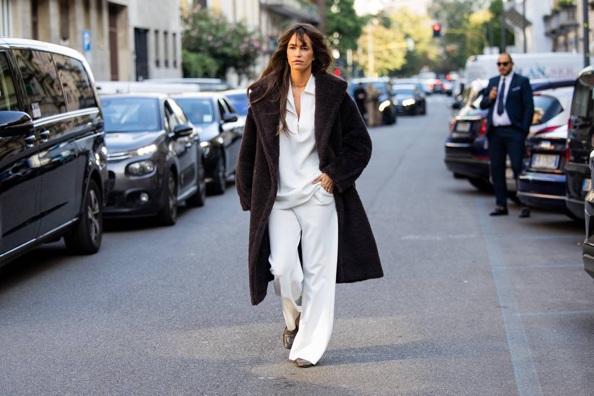 MILAN, ITALY - SEPTEMBER 24: Alison Toby wears a dark brown teddy coat, a white collared V-neck top, wide-leg white trousers, brown loafers and a gold choker necklace outside Max Mara on September 24, 2026 in Milan, Italy. (Photo by Christian Vierig/Getty Images)
