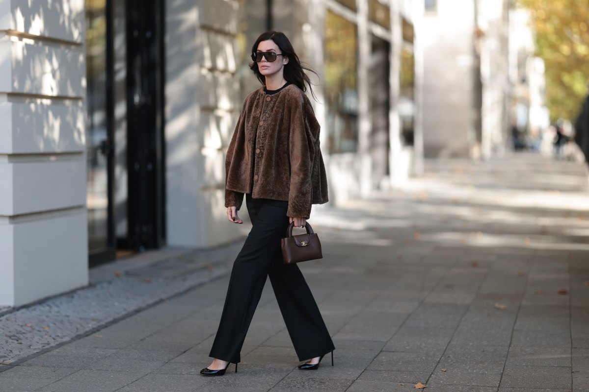 BERLIN, GERMANY - OCTOBER 5: Leo Eberlin seen wearing Tom Ford oversized black sunglasses with dark lenses, Manzoni 24 chocolate brown shearling jacket with a relaxed boxy silhouette and tonal button fastening, Zara fitted black crew-neck top, Leo Mathild diamond jewelry including stud earrings and statement rings, Audemars Piguet yellow gold watch, Chanel structured brown leather top-handle bag with gold-tone CC hardware, Sézane black tailored flared trousers with a clean high-waisted silhouette, Tom Ford black patent leather heels on October 5, 2026 in Berlin, Germany. (Photo by Jeremy Moeller/Getty Images)