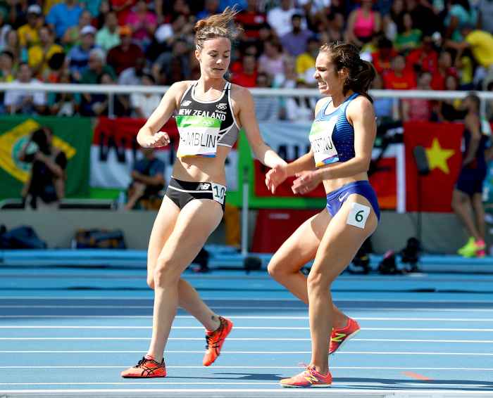 Abbey D'Agostino of the United States (R) is assisted by Nikki Hamblin of New Zealand after a collision during the Women's 5000m Round 1 - Heat 2 on Day 11 of the Rio 2016 Olympic Games at the Olympic Stadium on August 16, 2016 in Rio de Janeiro, Brazil.