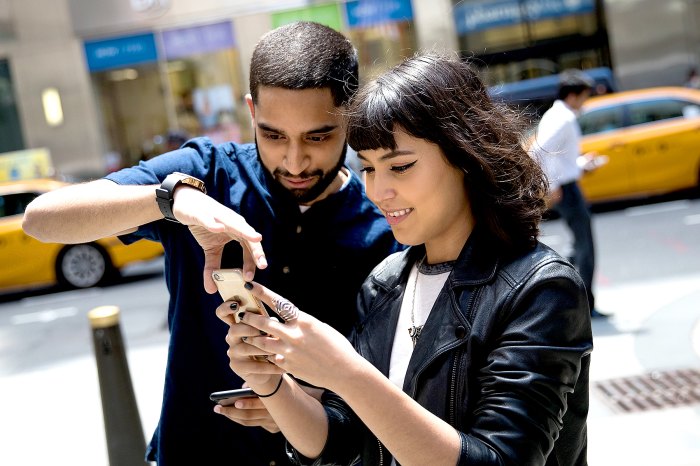 Sameer Uddin and Michelle Macias play Pokemon Go on their smartphones outside Nintendo's flagship store, July 11, 2016, in New York City.
