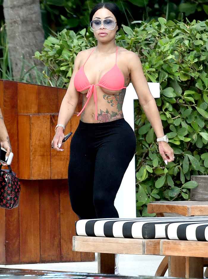 Blac Chyna shows off her post-baby body in a bright pink bikini top as she relaxes with friends by the pool in Miami. INSTARimages.com