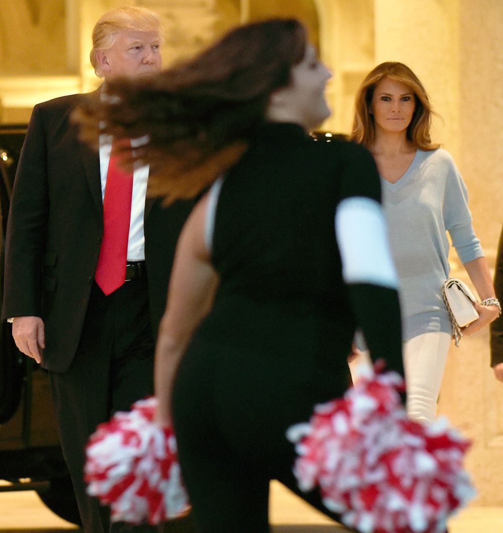 Donald Trump and first lady Melania Trump watch the Palm Beach Central High School Band as they play for their arrival at Trump International Golf Club in West Palm Beach, Fla., Sunday, Feb. 5, 2017.