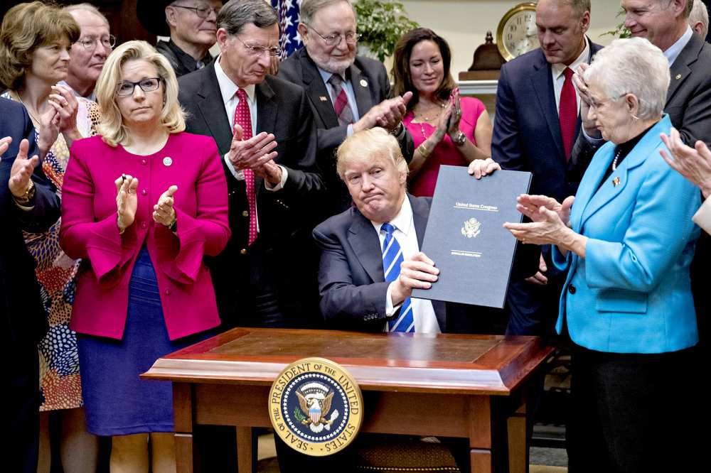 Donald Trump holds up H.J. Res. 58, which overturns a rule requiring states to report specific information on teacher preparation programs, such as student learning outcomes, and rate their effectiveness, after signing the bill during a ceremony in the Roosevelt Room of the White House in Washington, D.C., U.S., on Monday, March 27, 2017.