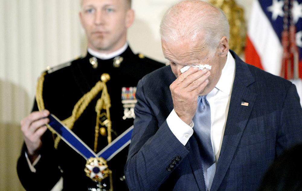 U.S. Vice President Joe Biden wipes his eyes as Preident Barack Obama presents him with Medal of Freedom during an event in the State Dinning room of the White House January 12, 2017 in Washington, DC.