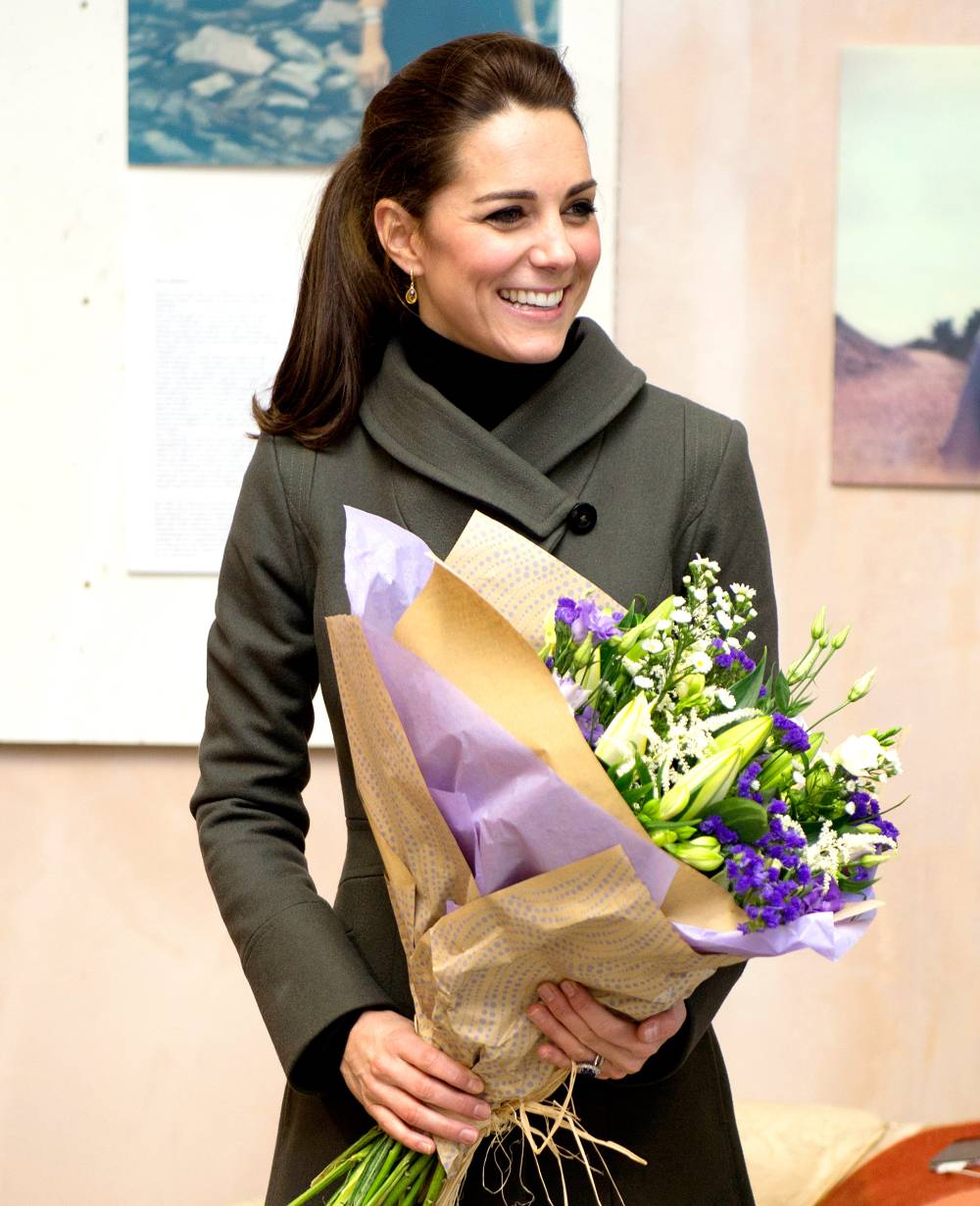 Kate Middleton receives a bouquet of flowers as she visits a photographic exhibition entitled