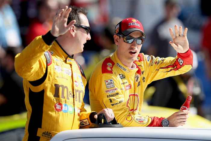 Kyle Busch, driver of the #18 M&M's Toyota, and Joey Logano, driver of the #22 Shell Pennzoil Ford, wave during driver introductions prior to the NASCAR Sprint Cup Series Can-Am 500 at Phoenix International Raceway on November 13, 2016 in Avondale, Arizona.