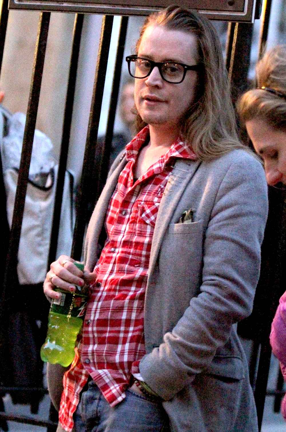 Macaulay Culkin pictured standing outside on the fire escape stairs as he films scenes for 'The Jim Gaffigan Show' in the Soho area of Downtown Manhattan, New York on March 13, 2016.