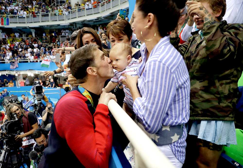 United States' Michael Phelps celebrates winning his gold medal in the men's 200-meter butterfly with his mother Debbie, fiance Nicole Johnson and baby Boomer during the swimming competitions at the 2016 Summer Olympics, Tuesday, Aug. 9, 2016, in Rio de Janeiro, Brazil.