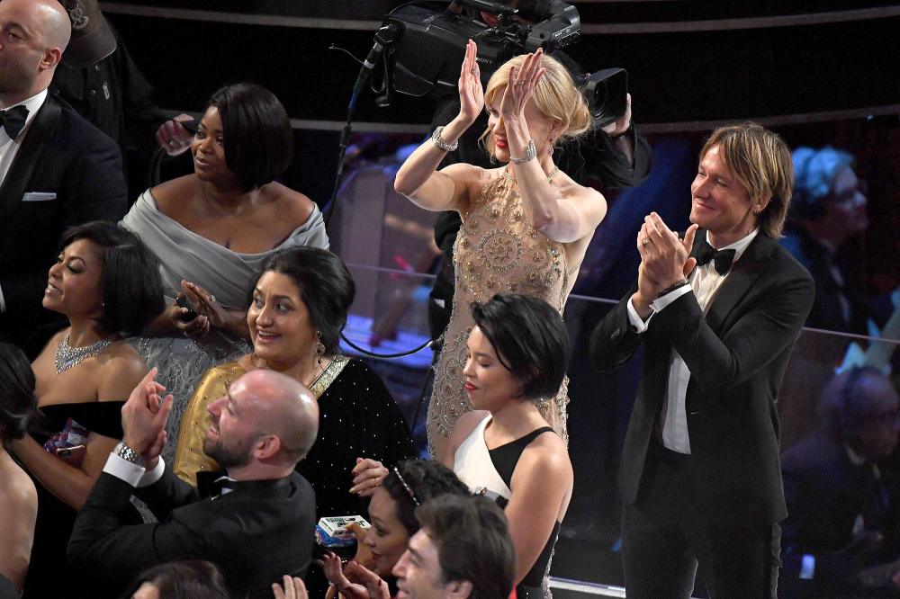 Nominee for Best Supporting Actress in "Lion" Nicole Kidman (C), her husband Australian singer Keith Urban (R) and nominee for Best Supporting Actress in "Hidden Figures" Octavia Spencer applaud as tourists are brought into the Oscars as a surprise at the 89th Oscars on February 26, 2017 in Hollywood, California.