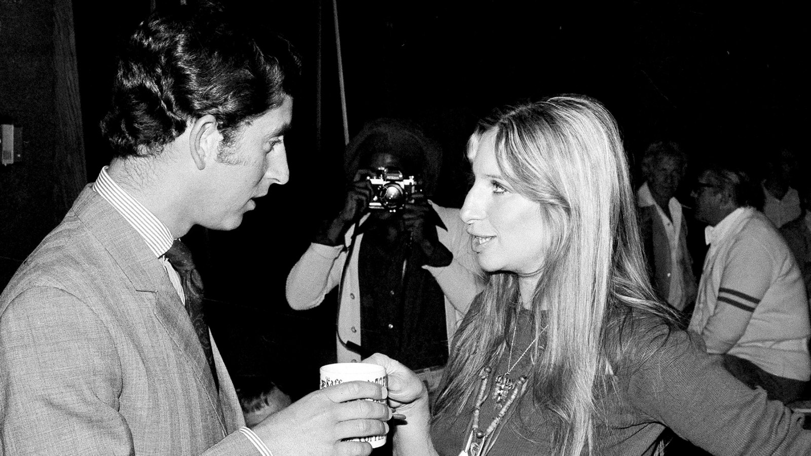 Barbra Streisand offers a cup of coffee to Prince Charles of Great Britain as they chat on a set at Warner Bros. studio in Los Angeles, CA, March. 19, 1974.