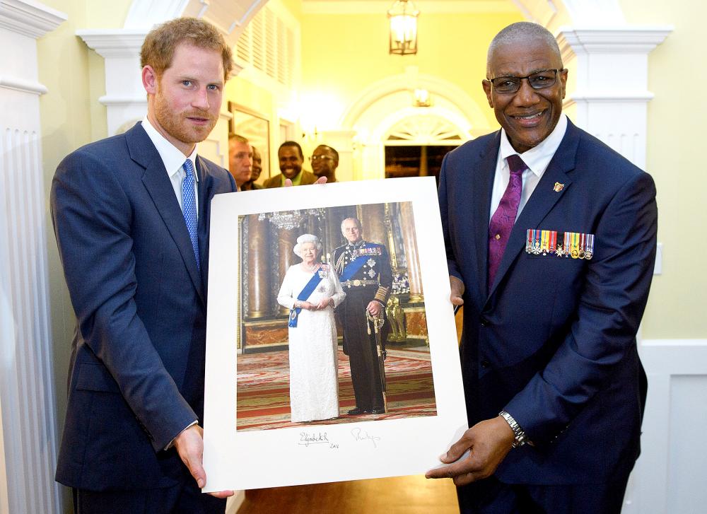 Prince Harry presents a photo of Queen Elizabeth II and Prince Philip, Duke of Edinburgh, as he attends a reception hosted by the Governor General, Sir Rodney Williams, at the newly renovated Clarence House on the first day of an official visit, on Nov. 20, 2016, in Antigua. Prince Harry's visit to the Caribbean marks the 35th anniversary of independence in Antigua and Barbuda and the 50th anniversary of independence in Barbados and Guyana.