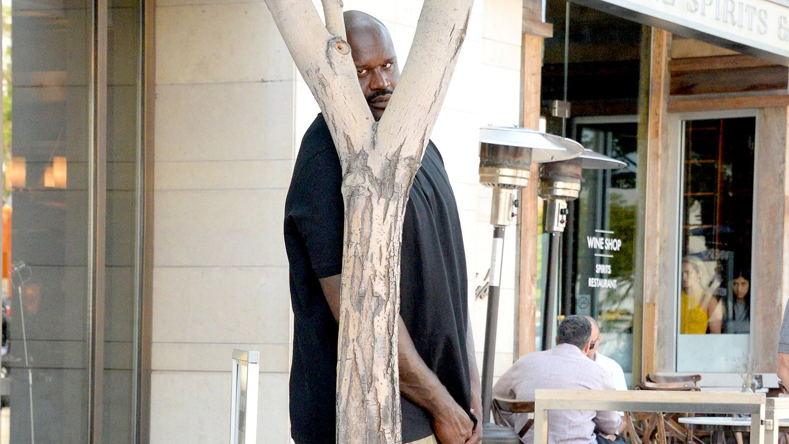 Shaquille O'Neal does his best to hide from paparazzi as he waits for his car after lunch at Wolfgang's Steakhouse in Beverly Hills.