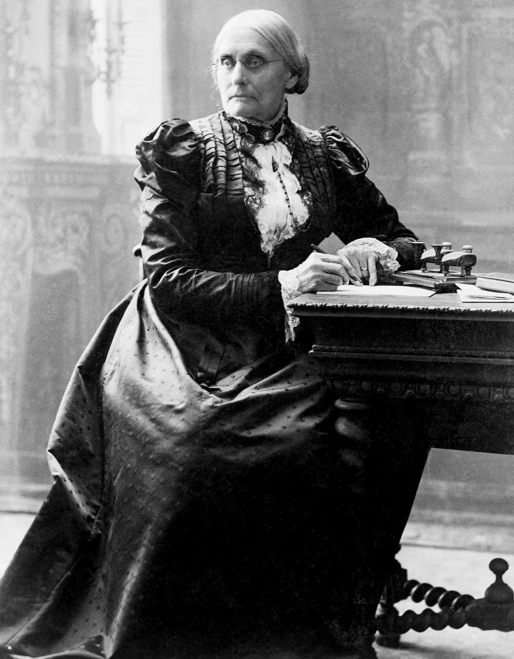 Susan B. Anthony (1820-1906), seated at her desk.