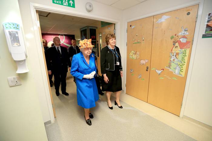 Queen Elizabeth II escorted by Kathy Cowell (R) Chairman of the Central Manchester University Hospital, during a visit to the Royal Manchester Children's Hospital on May 25, 2017 in Manchester, England.