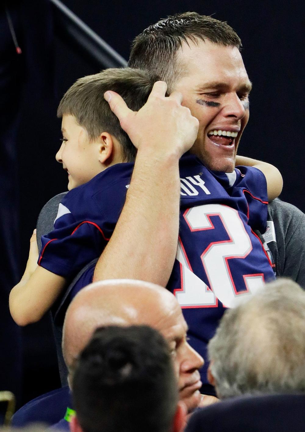 Tom Brady cries as he carries his son, Benjamin following the Super Bowl win