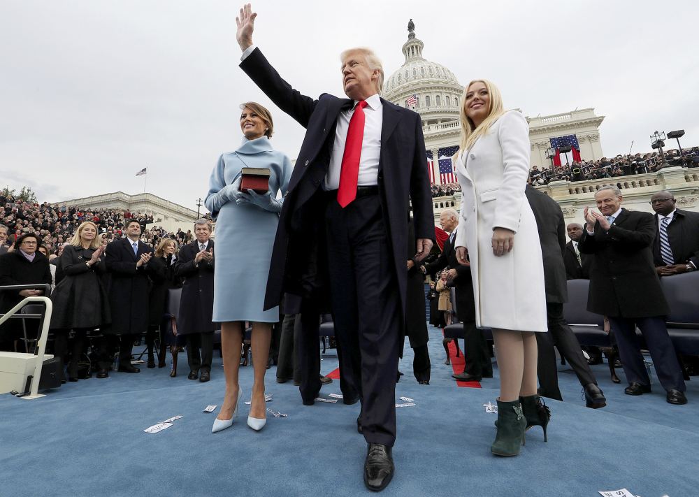 U.S. President Donald Trump, center, waves on stage with U.S. First Lady Melania Trump, left, and daughter Tiffany Trump during the 58th presidential inauguration in Washington, D.C., U.S., on Friday, Jan. 20, 2017. Jim Bourg/Pool via Bloomberg