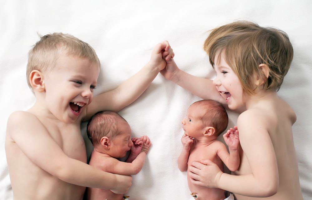 Toddler Twins Cuddling Their Newborn Twin Siblings