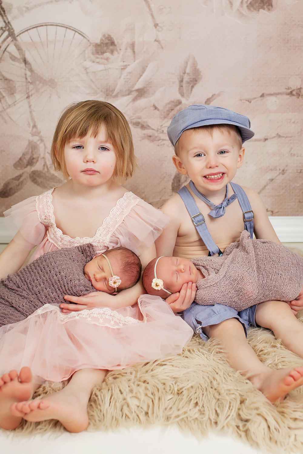 Toddler Twins Cuddling Their Newborn Twin Siblings bored